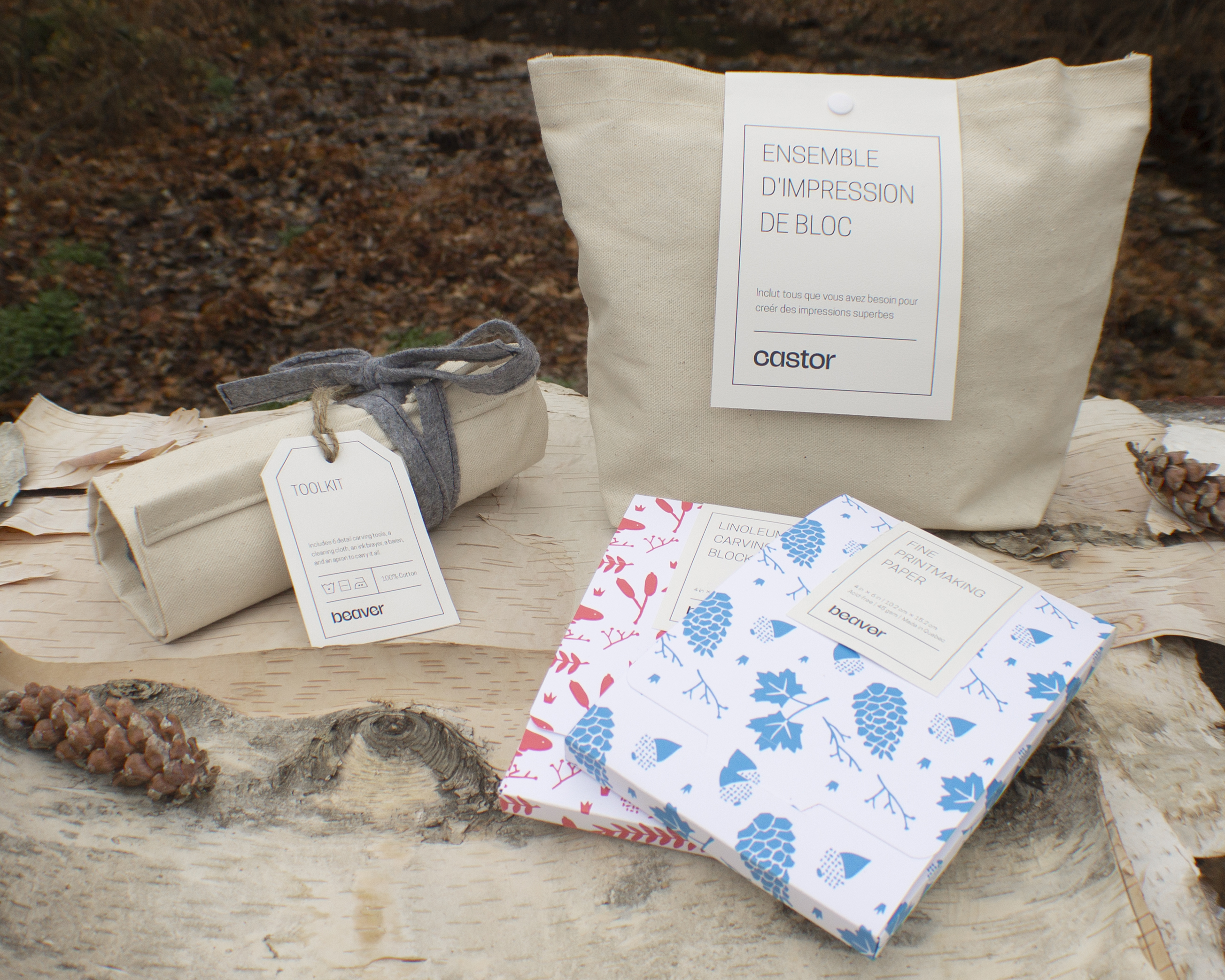 A spotlight photograph of the packaging for the Beaver block printing kit, showing the tool roll, canvas bag, and boxes of paper