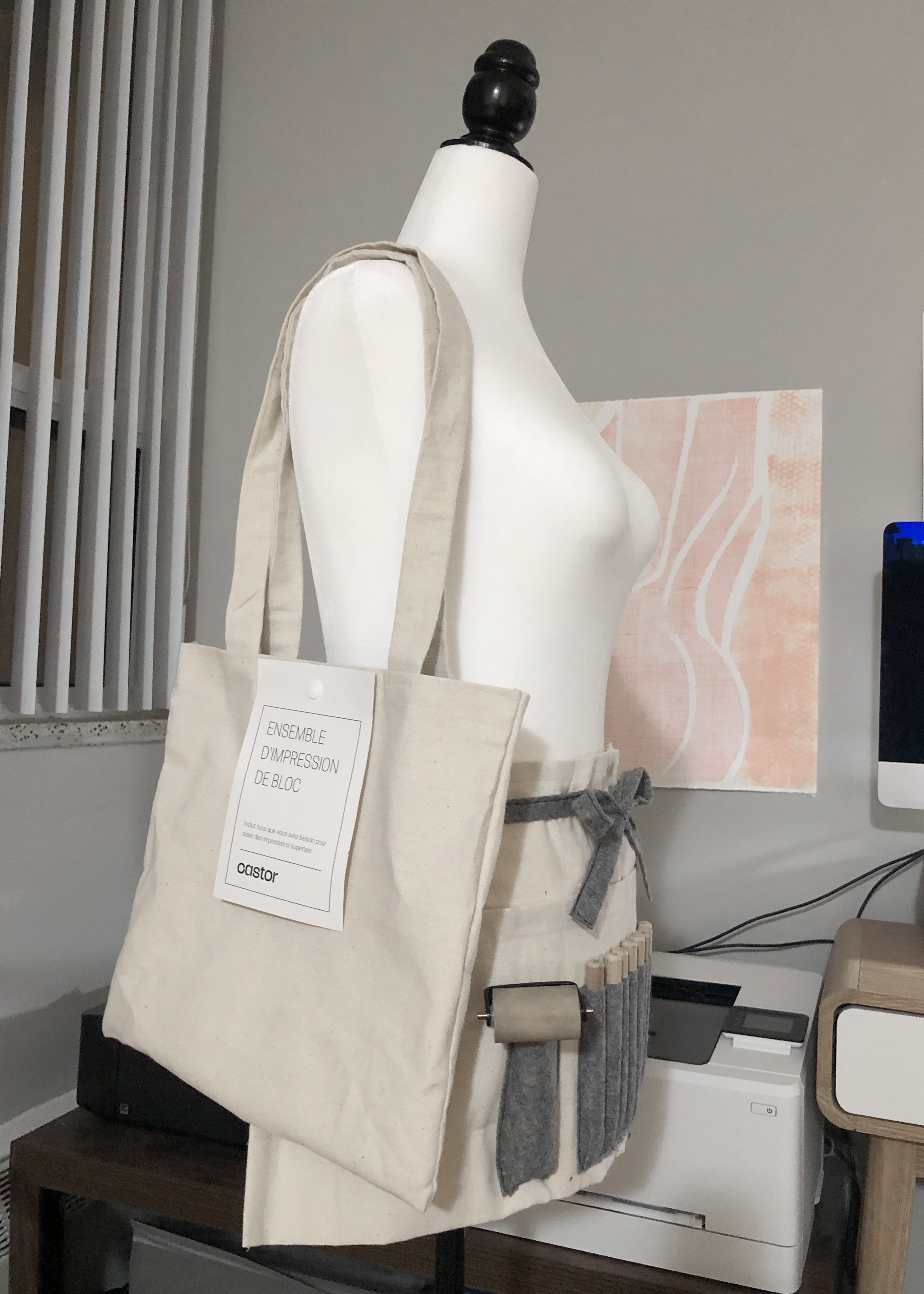 A photo of the canvas bag and half apron displayed on a dress form at an angle